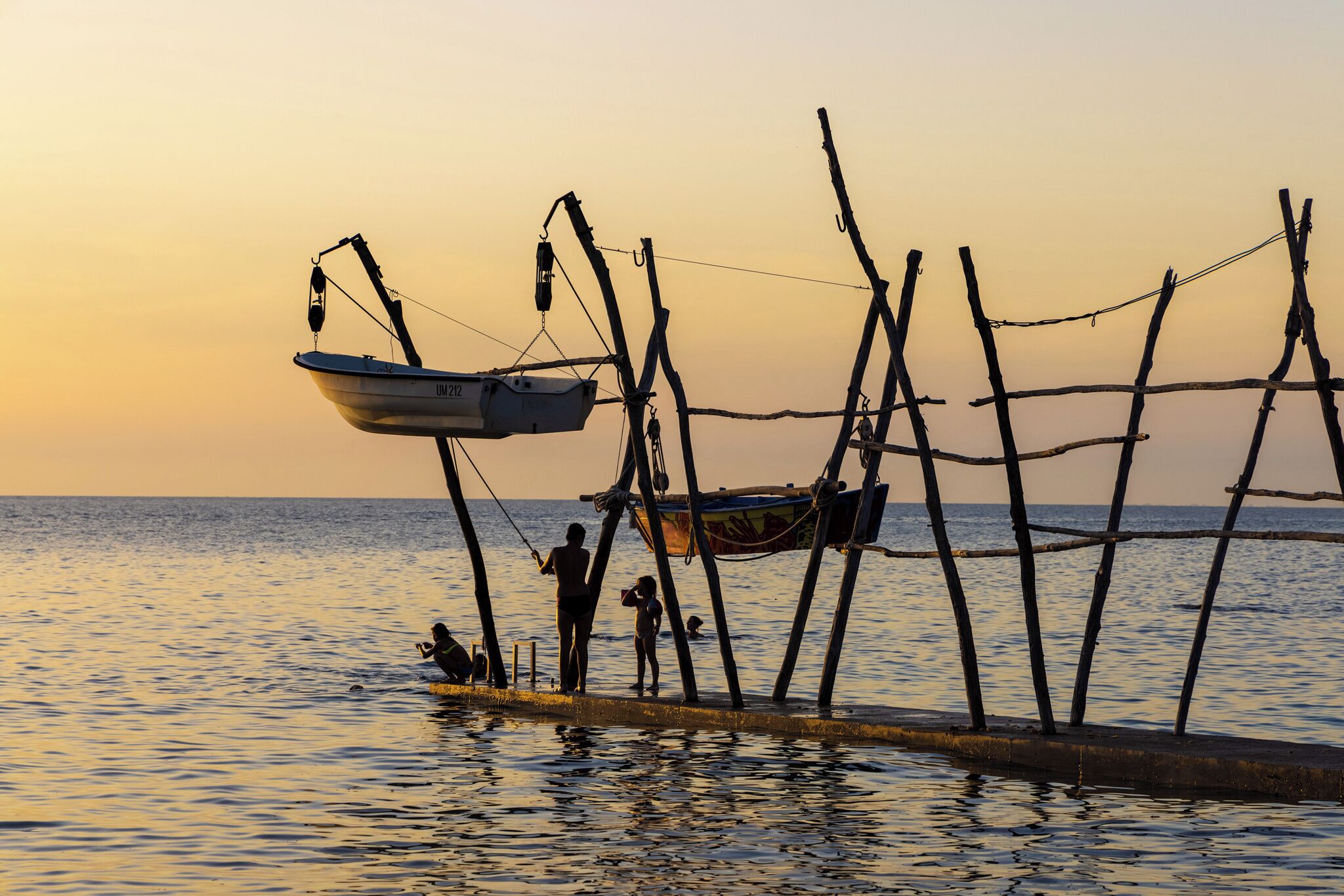 A pier with a boat and people, likely a dock or waterfront area.