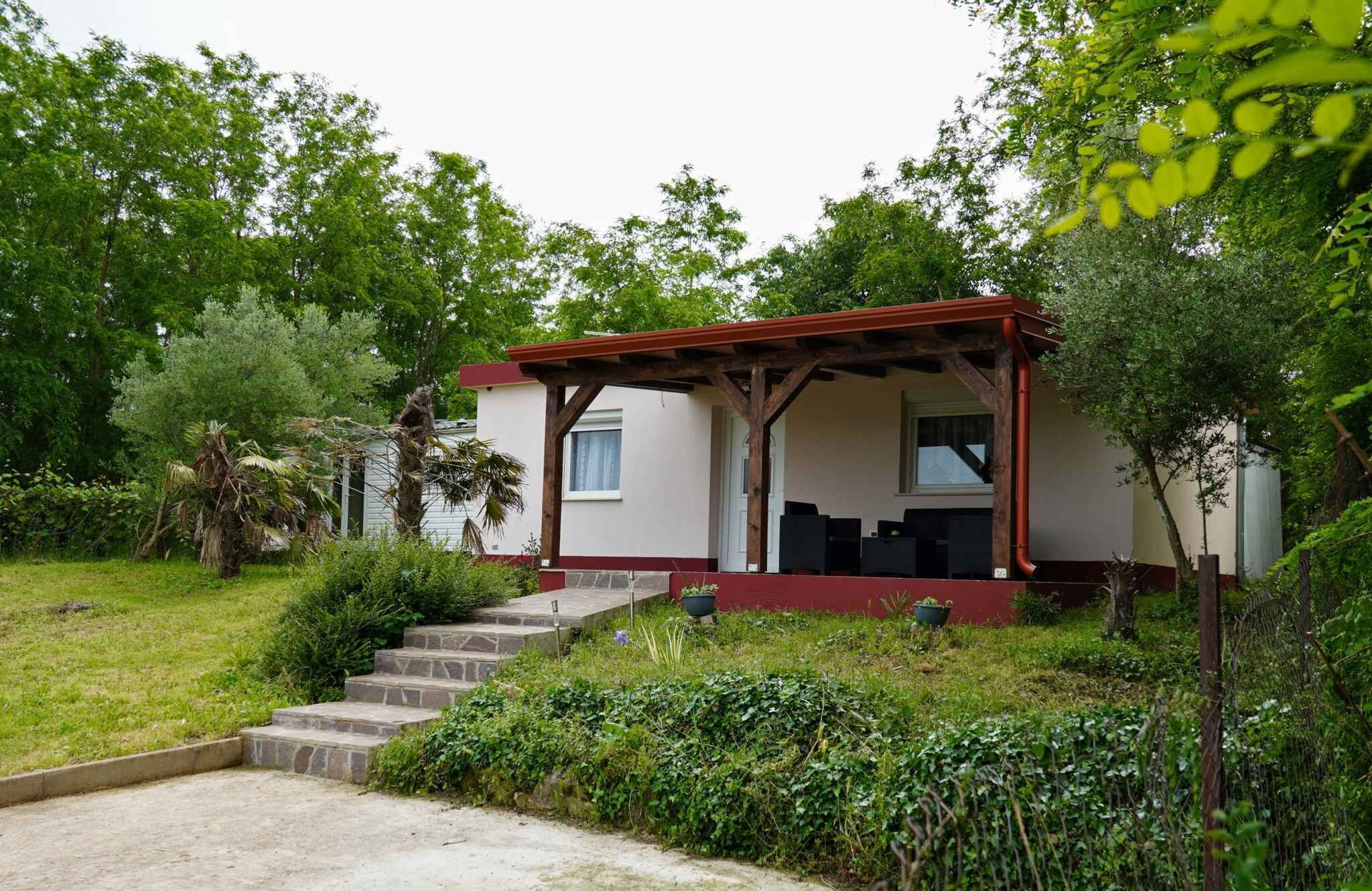 A small house with a porch, stone steps, and a garden.
