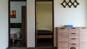 Una habitación con una cama, un armario y un pequeño mueble.