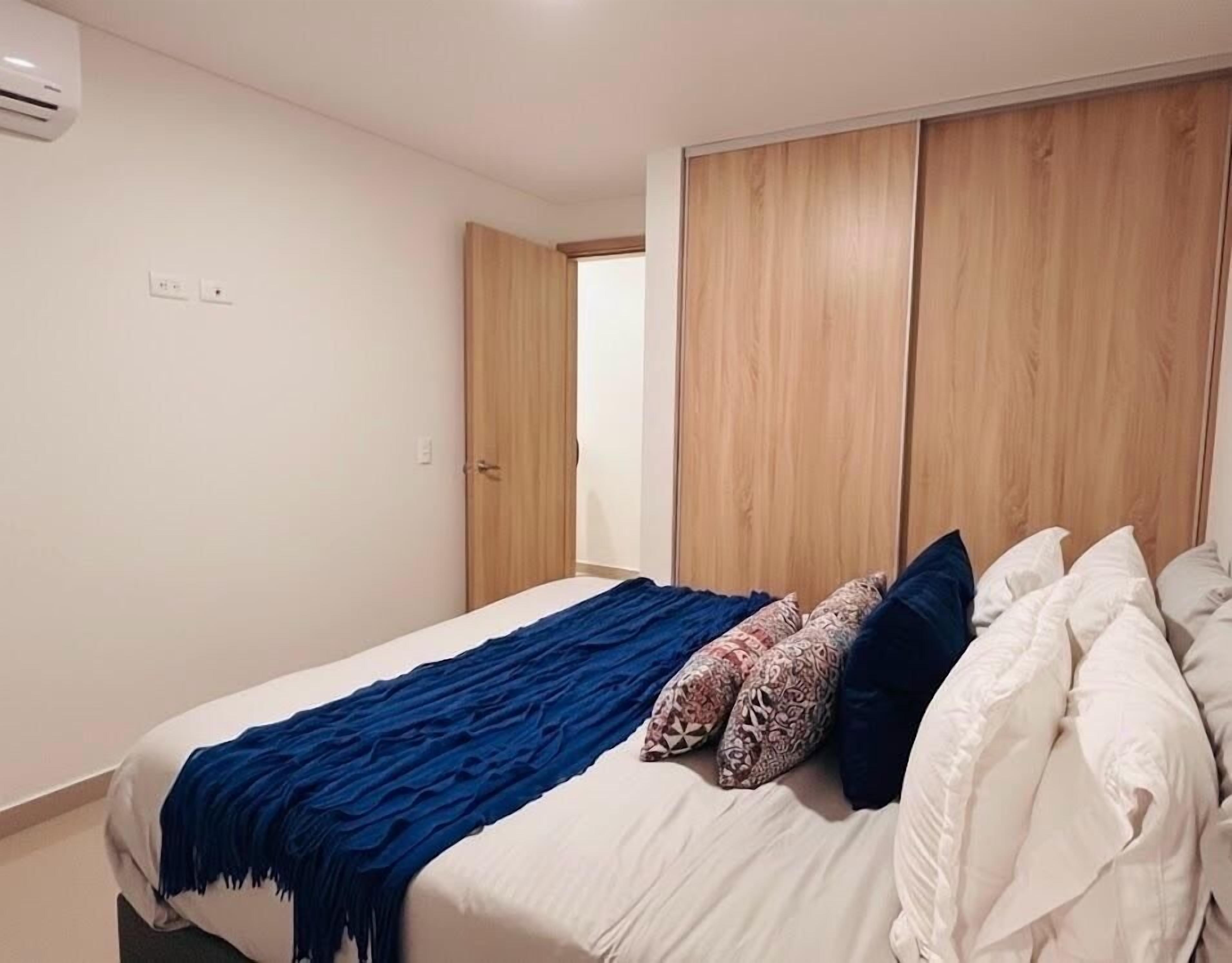 Une chambre à coucher avec un lit, une armoire en bois et une porte.