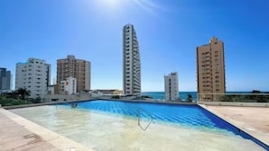 Una piscina con vistas a edificios altos y al océano.
