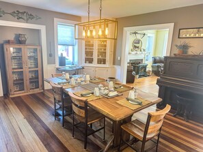 Enjoy dining in style with a beautifully set table for four, a traditional fireplace, and a piano.
