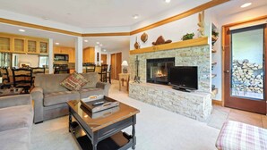 Amplia sala de estar con chimenea, televisor y asientos cómodos.