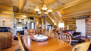 A wooden cabin interior with a dining area, kitchen, and living room. - 24-0089 Rustic Hartsel Getaway w/ 35-Acre Yard (Fairplay)