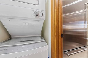 Vista frontal de una lavadora Whirlpool con una secadora de acero inoxidable a su lado.