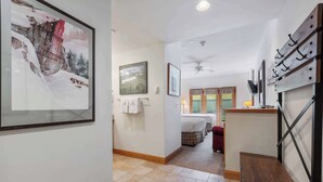 A hallway with a framed picture, a ceiling fan, and a bed in the background. - The Charter at Beaver Creek E0105 (Beaver Creek)