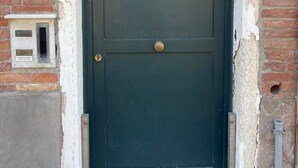 Una porta verda fosc amb una aldreta de bronze, una placa blanca amb el número "2226A", i una petita bústia a l'esquerra.