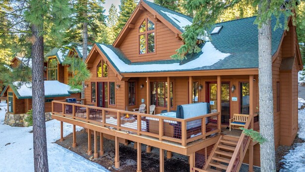 A wooden cabin with a deck, a fire pit, and a covered seating area. - Hot tub! Ski In/Out! Pool Table/PingPong Fireplaces! Mere feet from the Village! (Truckee)