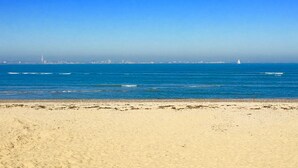 A beach with a clear view of the ocean and distant city skyline. - Zeta Cottage - Ryde, Isle of Wight (Ryde)