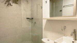 Ein modernes Badezimmer mit Toilette, Waschbecken und Dusche.