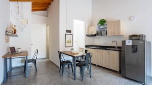 A modern kitchen with a wooden table, two chairs, a refrigerator, and a microwave. - AC loft/safe/Downtown (Medellín)