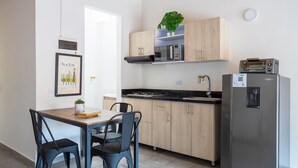 A modern kitchen with wooden cabinets, a microwave, a toaster, and a refrigerator. - AC loft/safe/Downtown (Medellín)