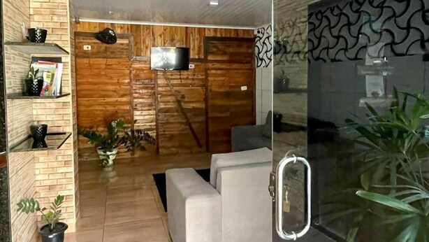 Una sala de estar moderna con un sofá, un televisor y un separador de vidrio.