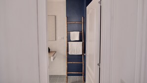 A bathroom with a white sink, a mirror, and a towel rack with two towels. - Moderno Apartamento en Puerto de Lacruz (Puerto de la Cruz)