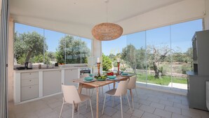 A modern kitchen with a large island, white cabinetry, and a view of the countryside. - TD Trulli Benedetta w/ Pool in Peaceful Nature (Castellana Grotte)