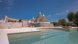 A swimming pool with a stone building in the background. - TD Trulli Benedetta w/ Pool in Peaceful Nature (Castellana Grotte)