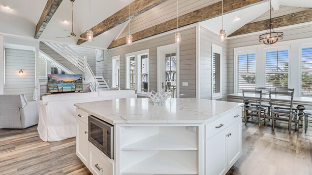 A spacious kitchen with a large island, white cabinetry, and a rustic ceiling. - Sea Ya at the Beach 237 MA (Port Aransas)
