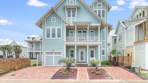 A two-story house with a front porch, a balcony, and a driveway with brick paving. - Sea Ya at the Beach 237 MA (Port Aransas)