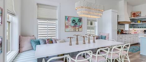 Een moderne keuken met een centraal eiland, witte kasten en een hanglamp.