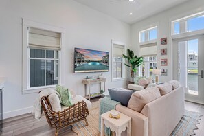 Relax in this stylish living room with a large flat-screen TV, comfortable sofa, and a beautiful view of the surrounding area.