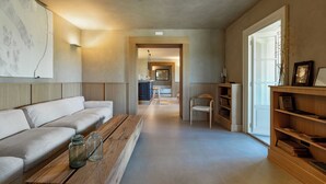 A modern living room with a sofa, wooden coffee table, and bookshelves. - Colle Alberti Country House (Cerreto Guidi)