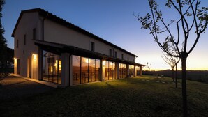 A modern house with large glass windows and a covered patio area. - Colle Alberti Country House (Cerreto Guidi)