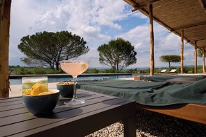 A poolside setting with a table, a drink, and snacks. - Colle Alberti Country House (Cerreto Guidi)