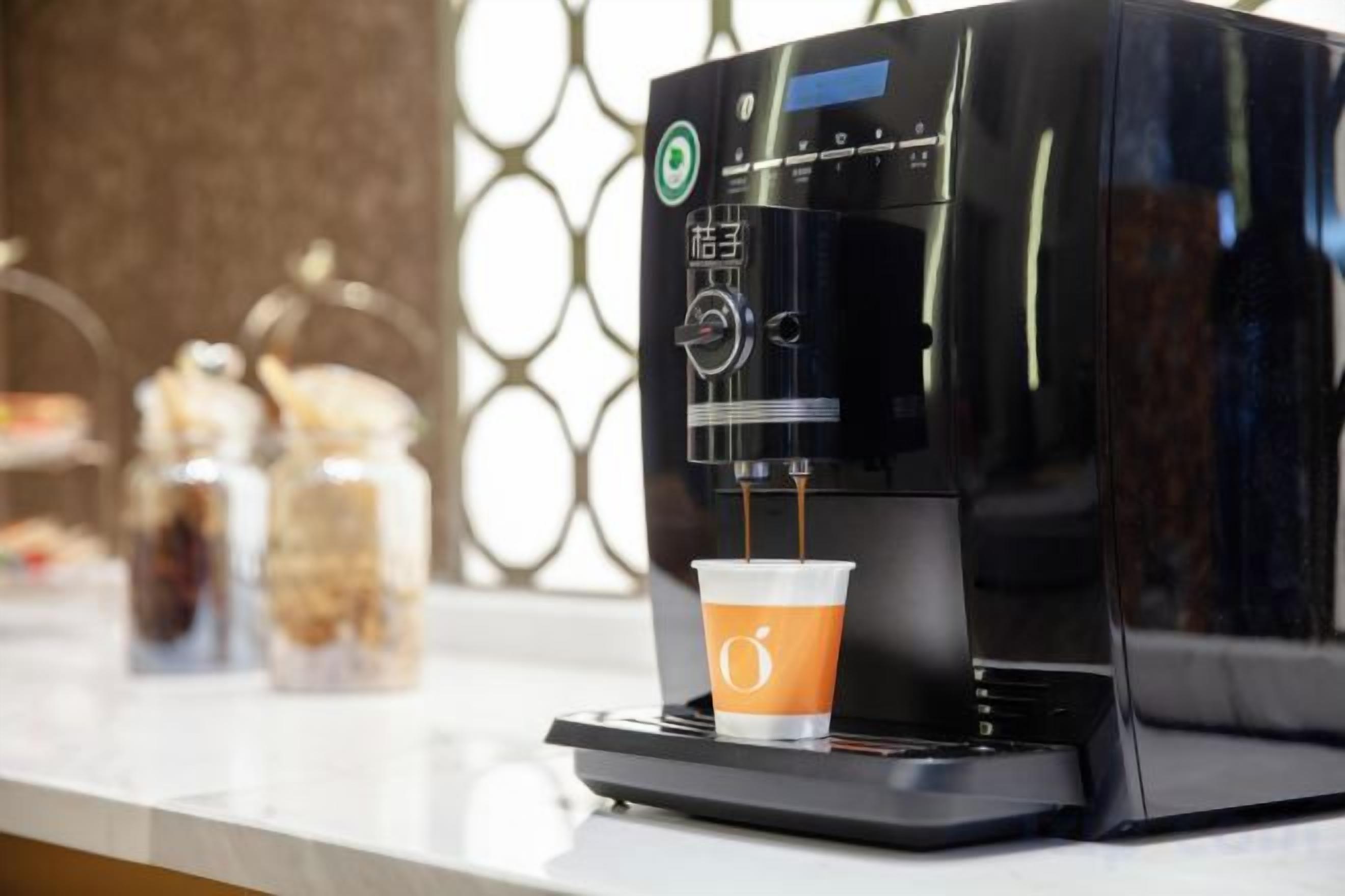 A coffee machine dispensing coffee into a cup.