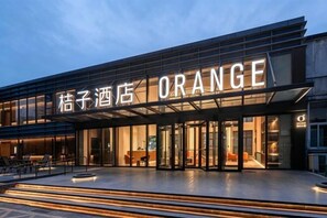Un hotel con una fachada moderna y un letrero que dice 'ORANGE'.