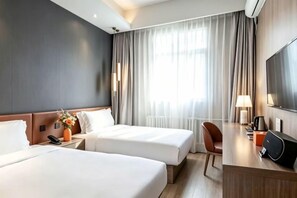 A hotel room with two beds, a desk, a TV, and a window with curtains. - Orange Hotel (Beijing Wangjing Subway Station) (Beijing)