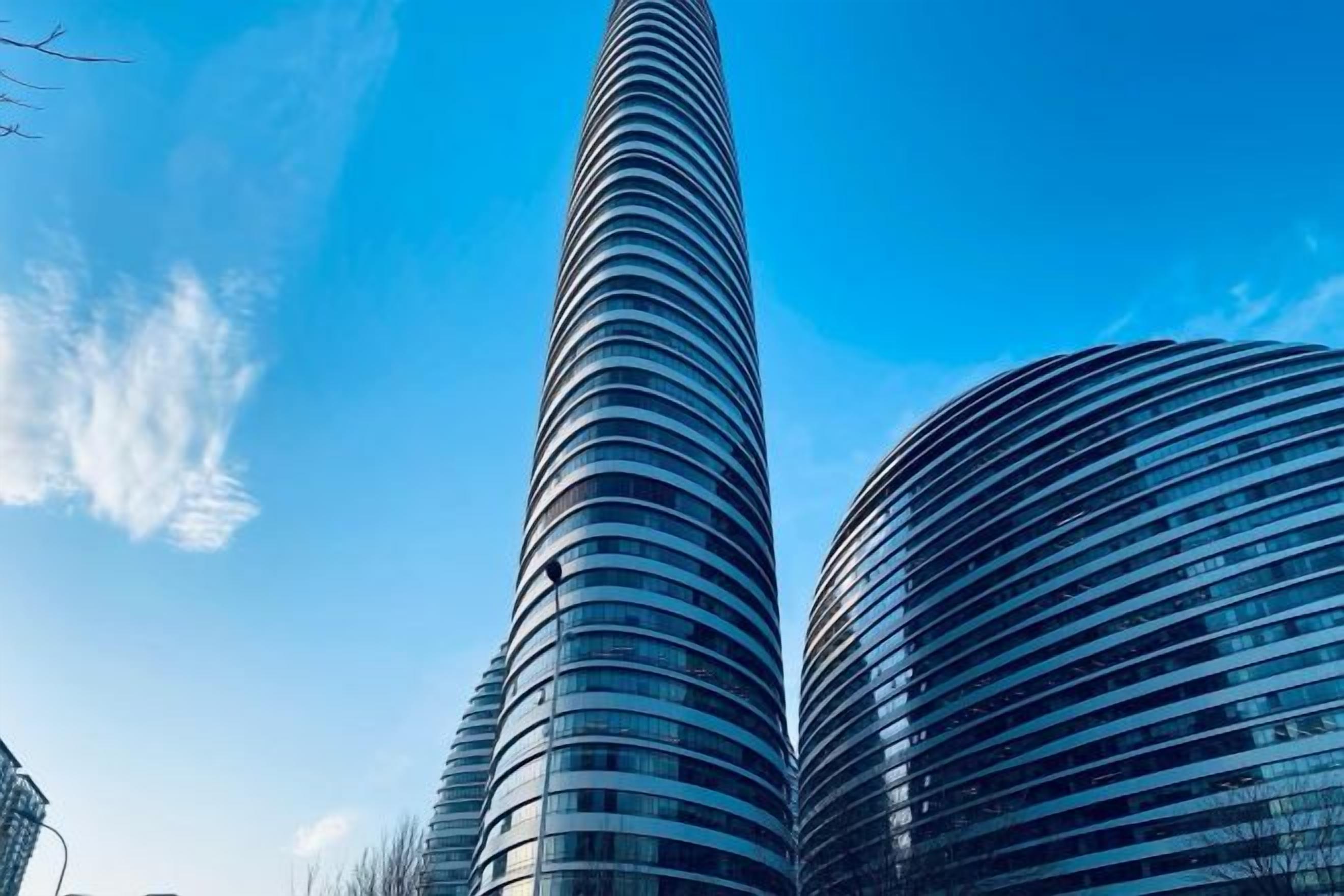 Two tall, cylindrical skyscrapers with reflective glass facades.