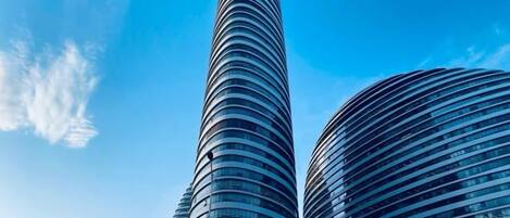Two tall, cylindrical skyscrapers with reflective glass facades.