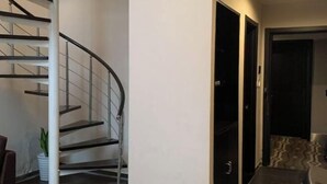 Un interno moderno con una scala a chiocciola, una sala da pranzo e un ingresso che conduce a un'altra stanza.