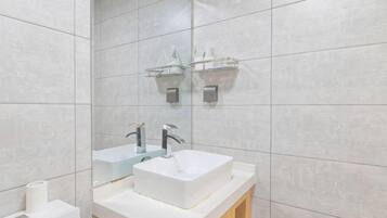 A bathroom with a white sink, two mirrors, and a towel rack.
