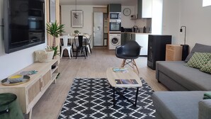 Un appartamento moderno con soggiorno, zona pranzo e cucina.