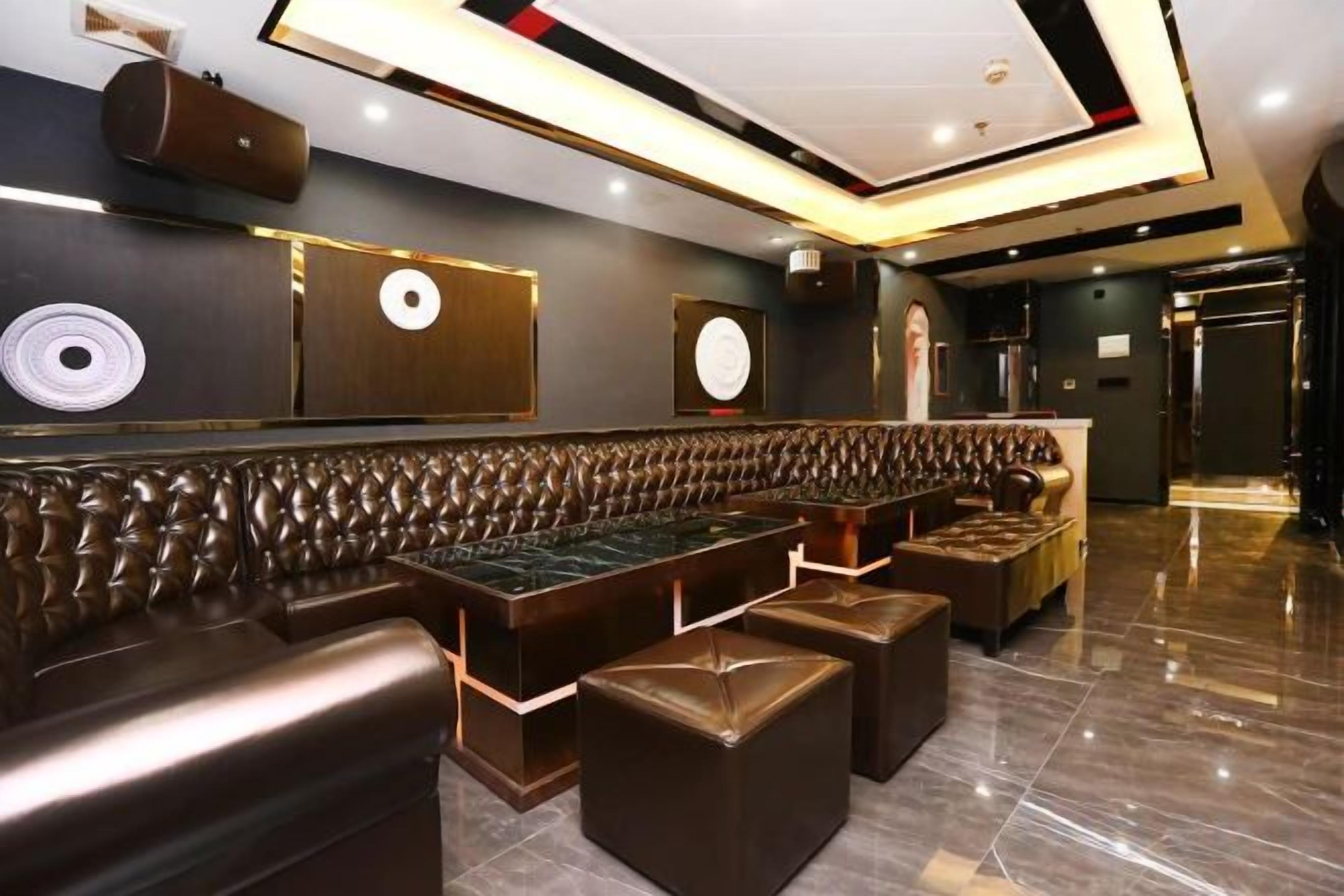 Un intérieur moderne avec un long espace salon doté de sièges confortables, un comptoir de bar et un plancher poli.