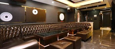 Un intérieur moderne avec un long espace salon doté de sièges confortables, un comptoir de bar et un plancher poli.