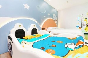 A child's bedroom with a bed, a playpen, and a wall with a space theme. - Baohua Hotel (Chaozhou)