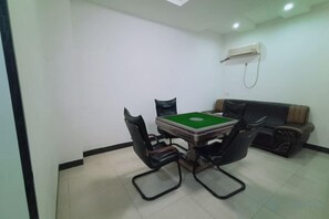 A room with a billiards table, two black chairs, a sofa, and an air conditioning unit on the wall. - Fogang Xingshu Fashion Hotel (Fogang)