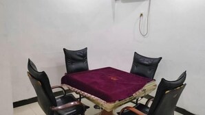 A dining table with a purple tablecloth, four black chairs, and a brown base. - Fogang Xingshu Fashion Hotel (Fogang)