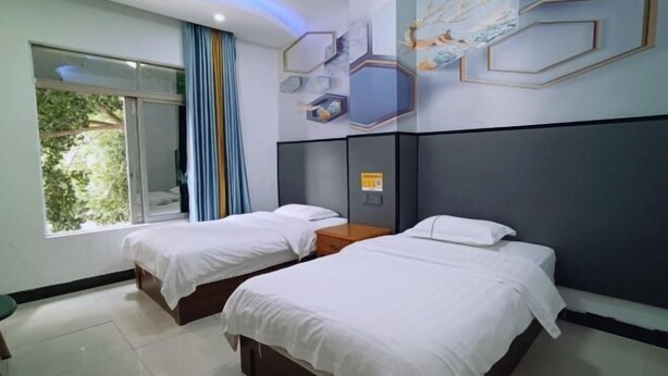 A hotel room with two beds, a large window with curtains, and a wall decorated with geometric patterns and artwork. - Fogang Xingshu Fashion Hotel (Fogang)