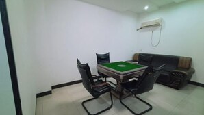 A room with a green pool table, four black chairs, a black sofa, and a white air conditioning unit on the wall. - Fogang Xingshu Fashion Hotel (Fogang)
