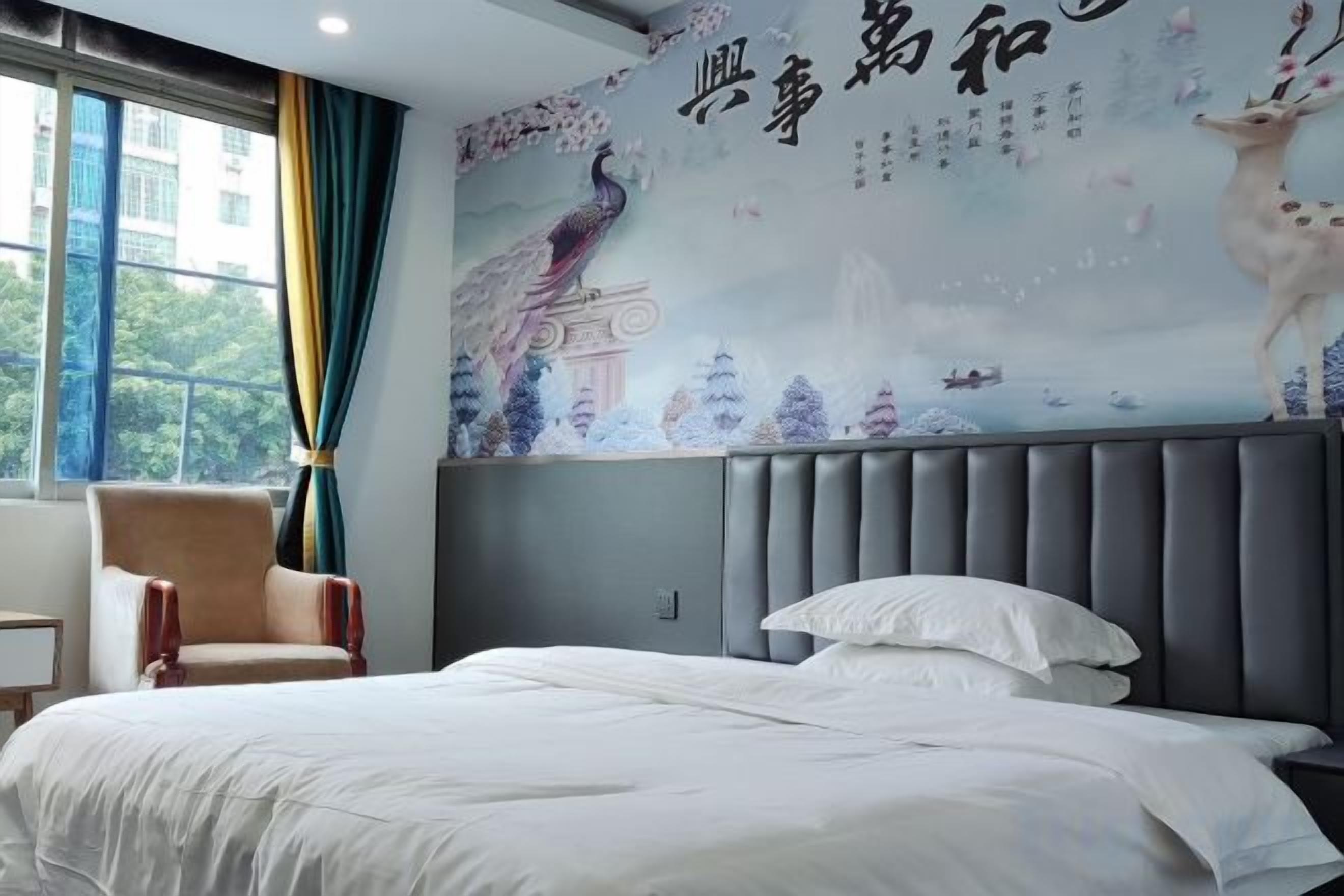 A hotel room with a bed, a chair, and a large wall mural.