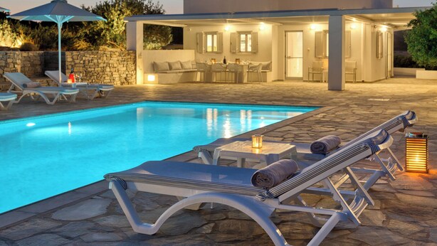 Ein moderner Poolbereich im Freien mit Liegestühlen und einer überdachten Terrasse.