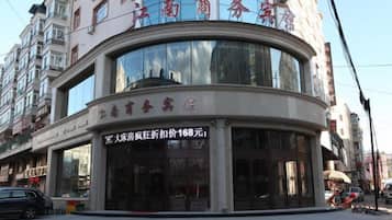 Un edificio comercial con fachada curva, ventanas amplias y señalización que indica un establecimiento para negocios.