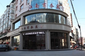 Un edificio comercial con fachada curva, ventanas amplias y señalización que indica un establecimiento para negocios.