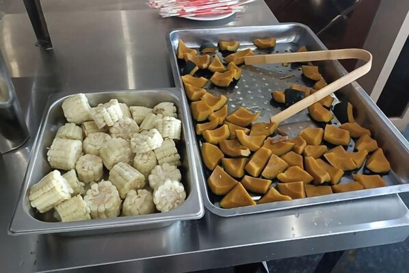 Una mesa de buffet con dos bandejas metálicas, una con alimentos en cubos y la otra con porciones triangulares.