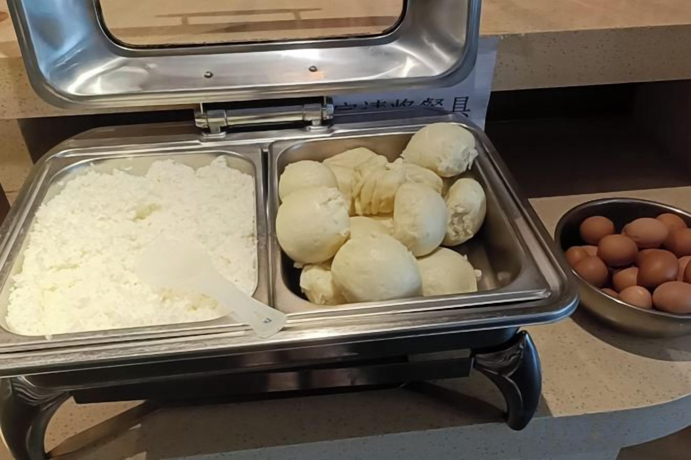A buffet with rice, dumplings, and eggs.