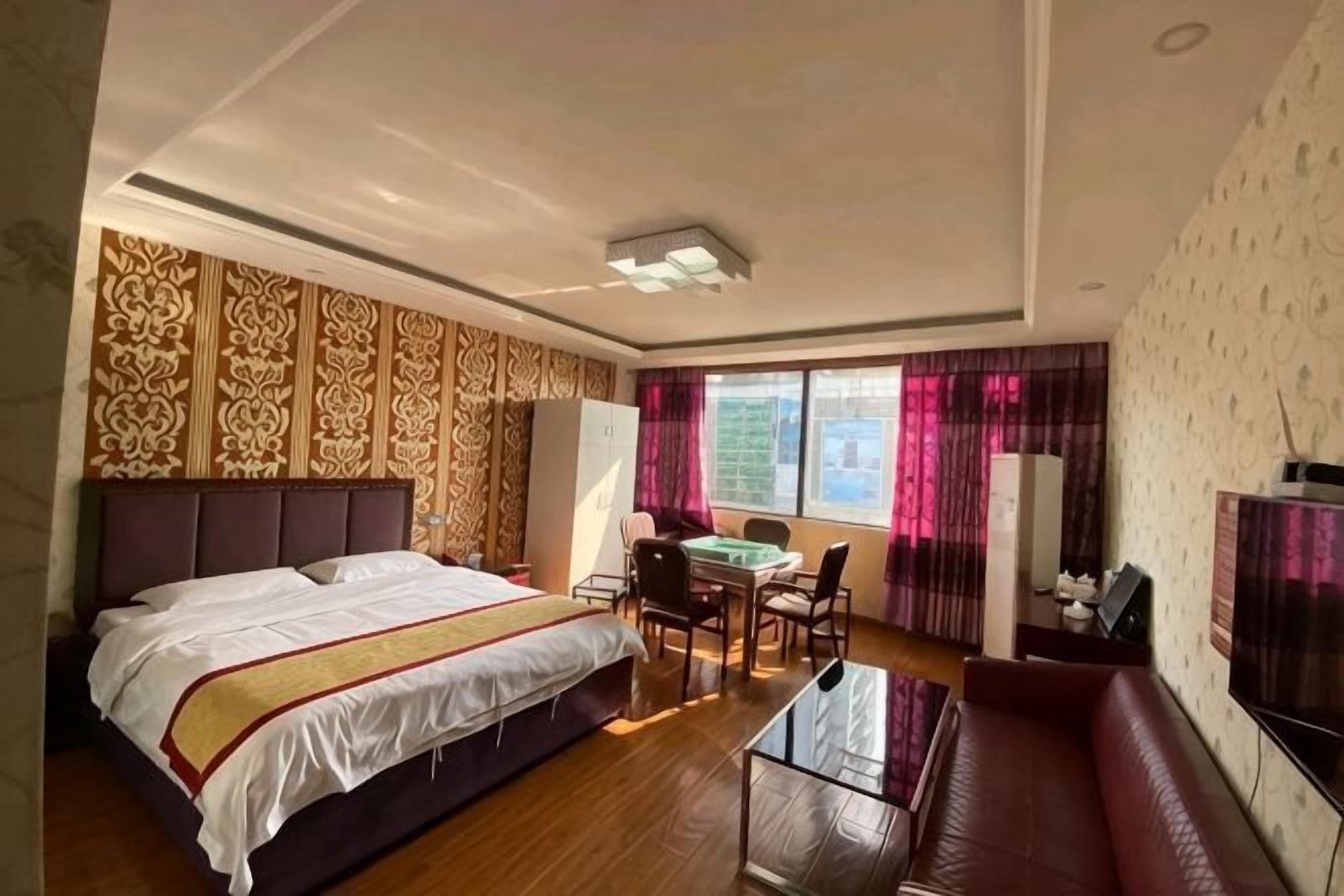 Una habitación de hotel con una cama grande, un escritorio con una silla, un sofá y un televisor.