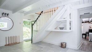 A modern interior with a staircase, a mirror, and a shelf unit. - Briardene - 2 Bedroom Cottage - Oxwich (Swansea)